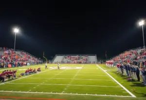 Football game with fans cheering under stadium lights